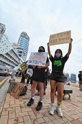 A group of people holding posters during the Busan BLM protests in South Korea