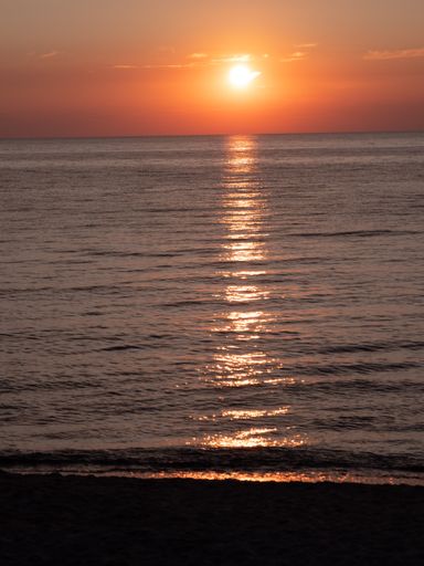 A vertical shot of the red sunset above the sea
