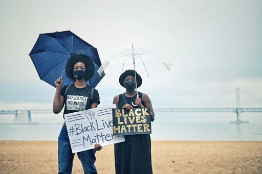 A portrait of two women holding posters during the Busan BLM protests in South Korea