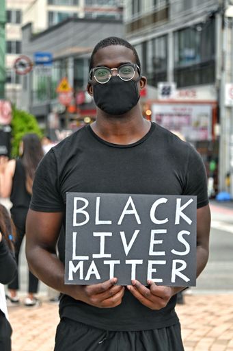 An African  protesting with a "black lives matter" poster during the BLM protests in Busan, South Korea