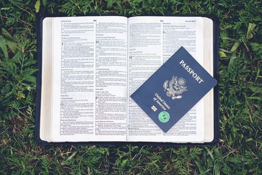 A top view of a passport on the open Bible