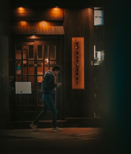 A young boy walking on the city street at night in South Korea