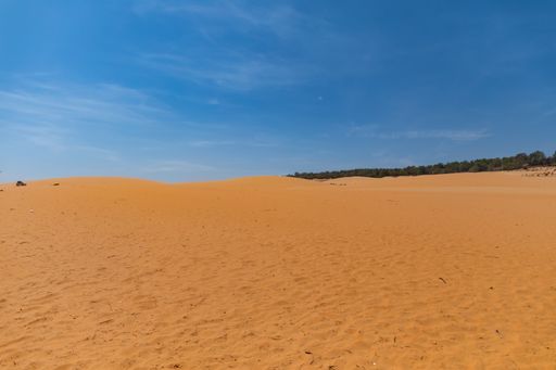 A panoramic shot of Red Sand Dunes in Mui Ne, Vietnam with a clear blue sky
