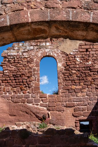 A closeup of an old castle red brick rus and an empty window frame