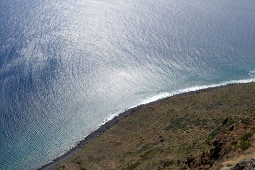 A high angle shot of an ocean and hills