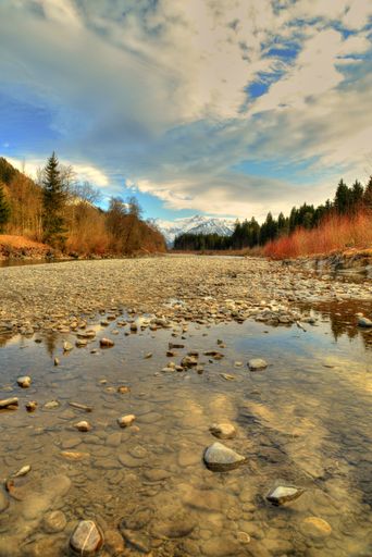 Landscape in the Allgaeu, near Fuessen in Germany, river with snow covered mountains, alps