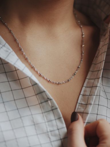 A closeup shot of a female wearing a beautiful silver necklace