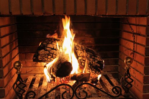 A fireplace with burning wood logs, cozy warm home time