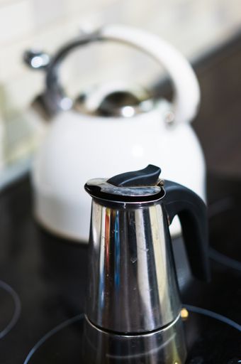 A vertical shot of a coffeemaker on the stove