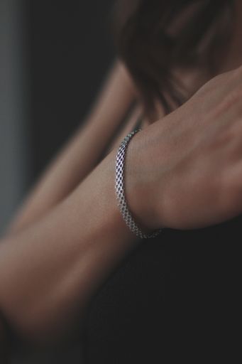 A vertical shot of a young female wearing a beautiful silver bracelet