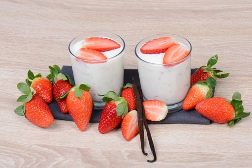 Yogurt with fresh straberries in glasses, wodden background, empty copy space for text