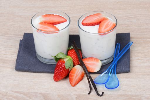 Yogurt with fresh straberries in glasses, wodden background, empty copy space for text