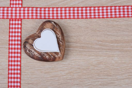 A heart-shaped ornament and tapes on the corner of a wooden surface for background