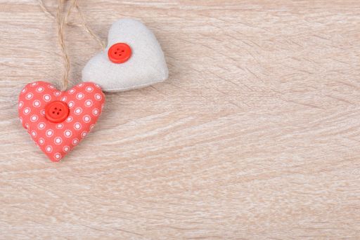 A closeup shot of sewed hearts on a wooden background for greeting card and holidays