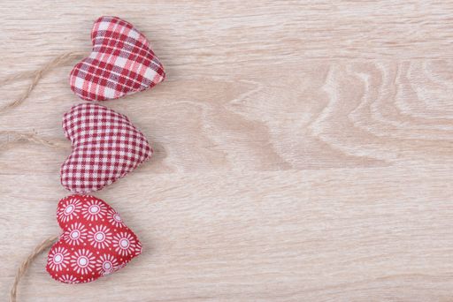 Various heart-shaped ornaments on the wooden background with copy space on the right
