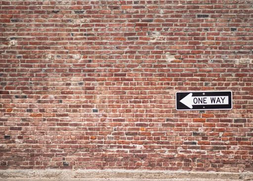Beautiful Rustic Brick wall with a one way sign attached to the side of the wall. Great for backgrounds.