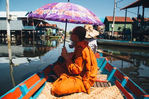 A Cambodian Buddhist monk standing by the serene waters of Tonle Sap, Cambodia