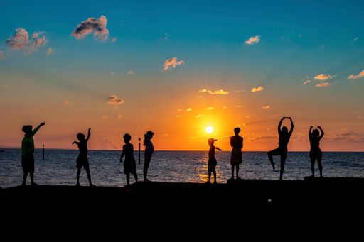The silhouettes of people having fun on a beach during the sunset