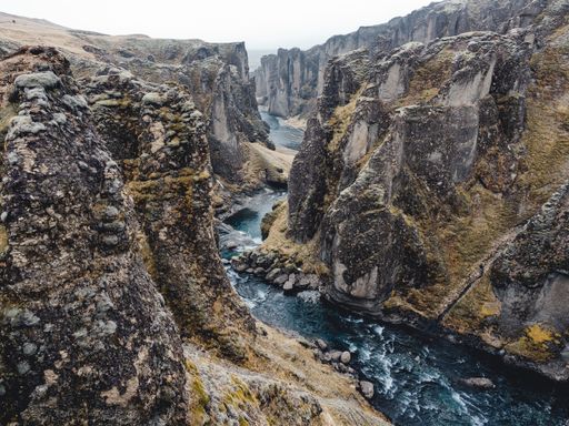 A breathtaking view of Fjaorargljufur canyon in Iceland, showcasing rugged cliffs and a winding river.