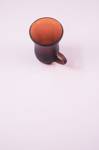 A vertical shot of an empty cup of coffee on a white surfac