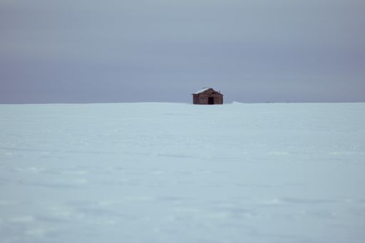A wide angle shot of a house surrounded by snow