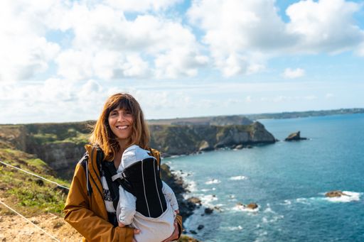 A female with her baby on a coastal path next to the Fort des Capucins on the background of a sea