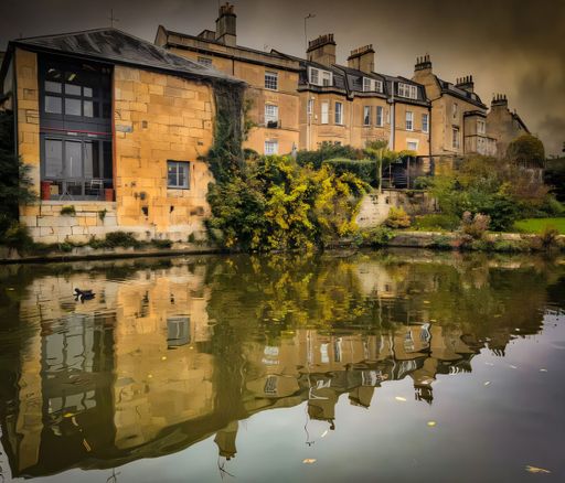 Charming historic buildings reflected in a calm river in Bath, UK, with lush greenery and a serene atmosphere.