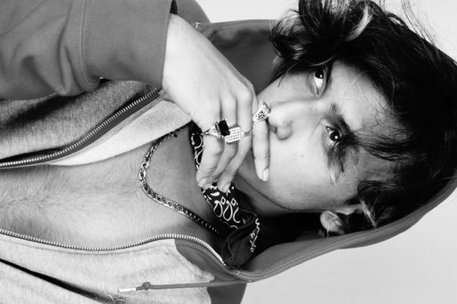 A grayscale of an Indian hipster guy posing to the camera