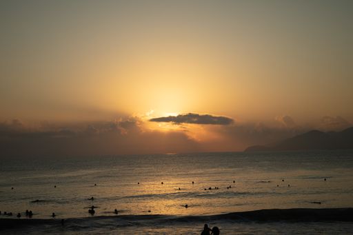 A beach shore with the sun shining behind the clouds in Nha Trang