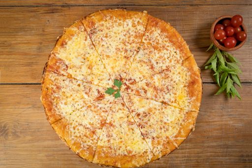 A top view of the freshly baked delicious cheesy pizza on the plate on the wooden surface