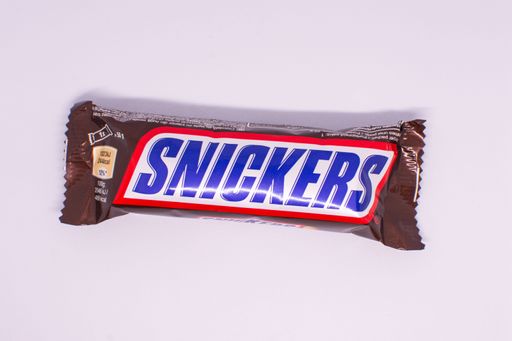 A Snickers chocolate bar isolated on a white background