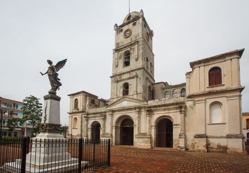 The El Angelote angel statue and the facade of Iglesia de San Jose, San Jose park in downtown Holguin, Cuba