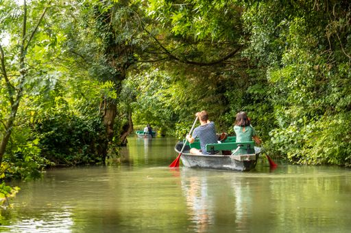 A young couple rowing a boat between La Garette and Coulon near the town of Niort, France