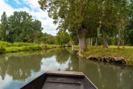 A boat sailing on the water channels between La Garette and Coulon near the city of Niort, France