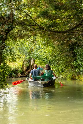 A young couple rowing a boat between La Garette and Coulon near the town of Niort, France