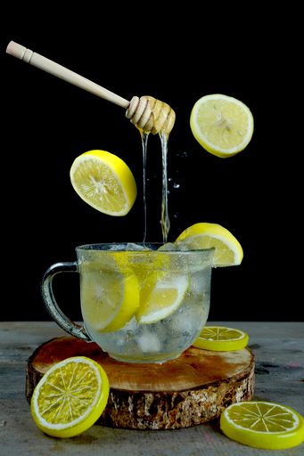A vertical shot of floating honey dipper on an iced lemonade - perfect for drink menu