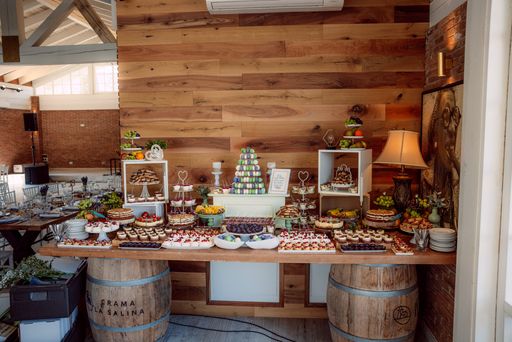 A rustic dessert table with assorted pastries and fruits in a cozy wooden interior setting, perfect for a wedding or event.