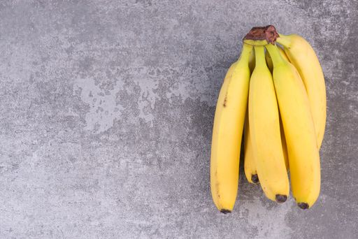 A bunch of ripe bananas on a texture background, empty copy space for text, fruits