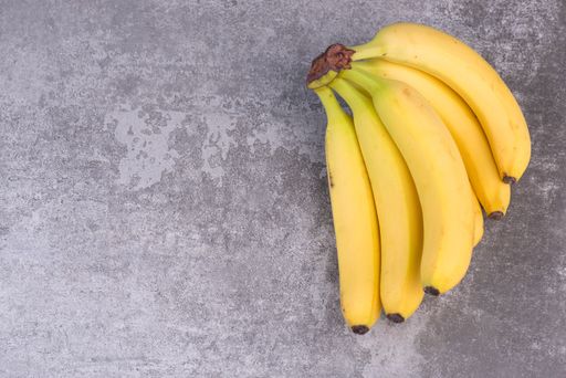 A bunch of ripe bananas on a texture background, empty copy space for text, fruits