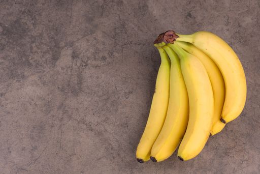 A bunch of ripe bananas on a texture background, empty copy space for text, fruits