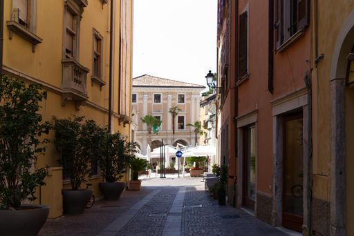 A beautiful street of Salo in Italy with buildings and outdoor plants on a sunny day