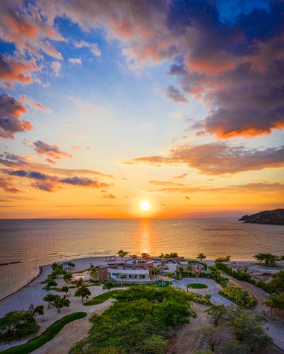 A vertical shot of a resort area surrounded by the sea during the sunrise in the Dominican Republic