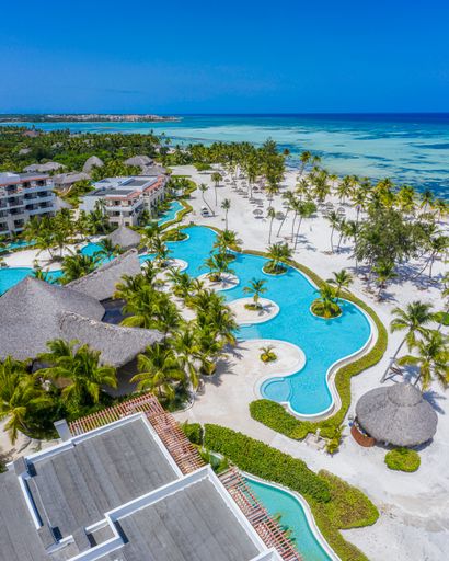 A vertical shot of a resort area surrounded by palm trees and the sea in the Dominican Republic