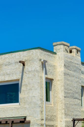 A modern residential building with gray-painted walls and a chimney under a clear sky