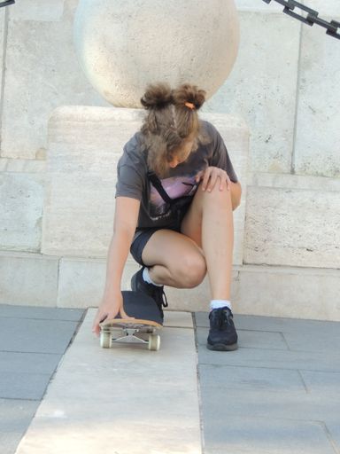 A vertical closeup of a girl with a skateboard.