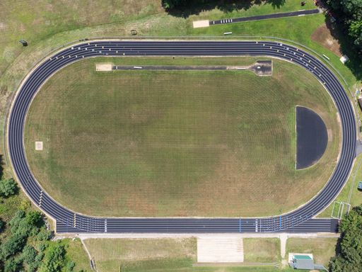 A top-down aerial photo of a black-colored running track