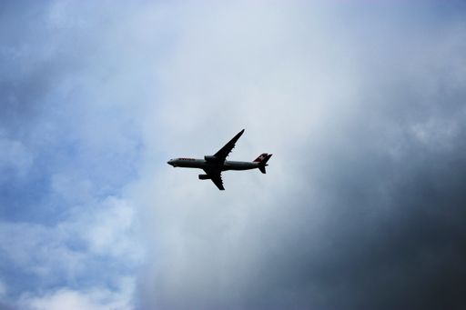 A big plane flying in the cloudy sky