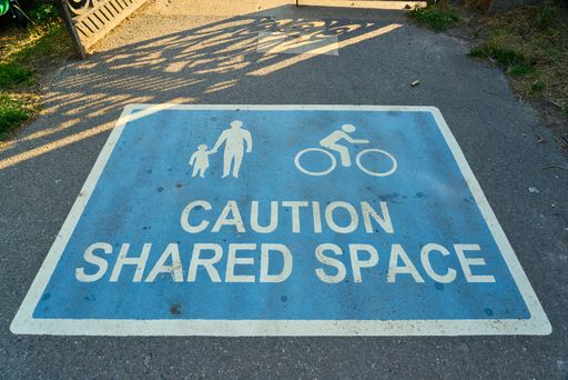 A closeup shot of a sign on the road warning about shared space for cyclists and pedestrians