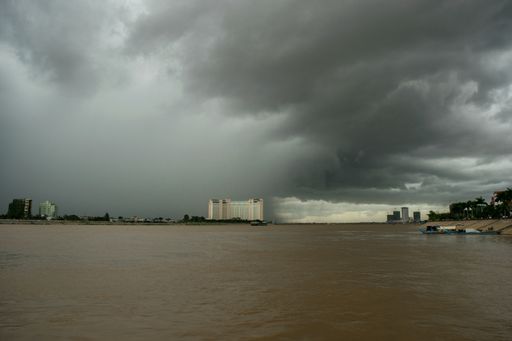The dark gloomy clouds and heavy monsoon rain falling on the confluence of the Tonle Sap and Mekong