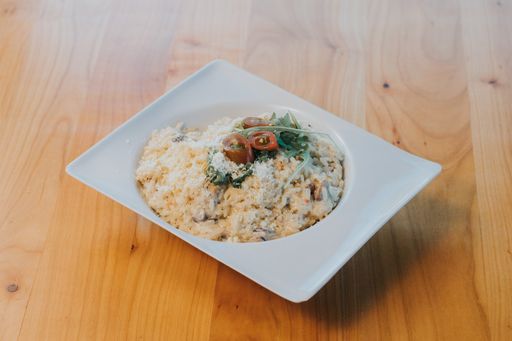 A high angle shot of cooked mushroom risotto on a white plate